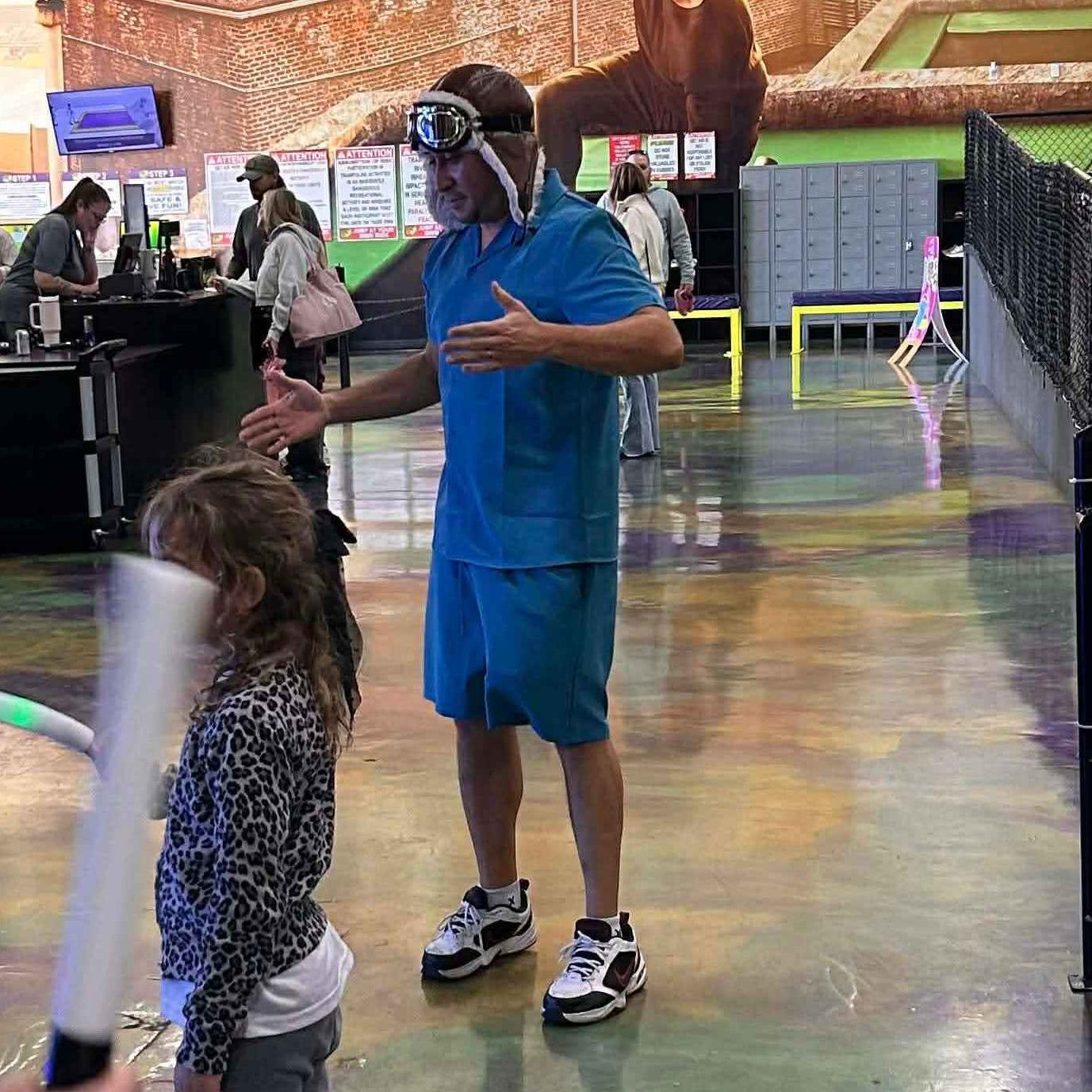 People interacting in a colorful indoor play area with large murals on the walls.